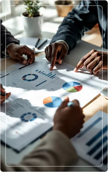 cis-consultoria-regularizacao-fiscal Profissionais em reunião corporativa apontando para relatórios e gráficos circulares, realizando auditoria preventiva e saneamento de pendências fiscais.